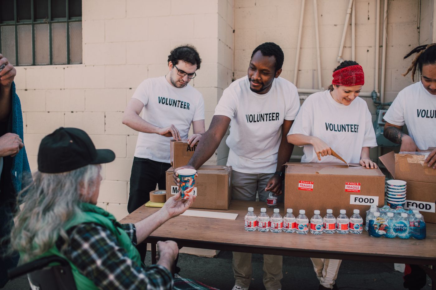Volunteers giving food donations at a community table